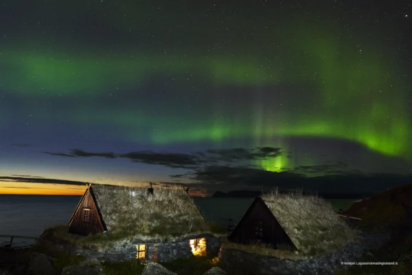 Northern lights over old farm houses in Bolungarvík in west Iceland