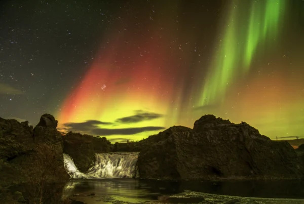 mega northernlights over hjalparfoss waterfall